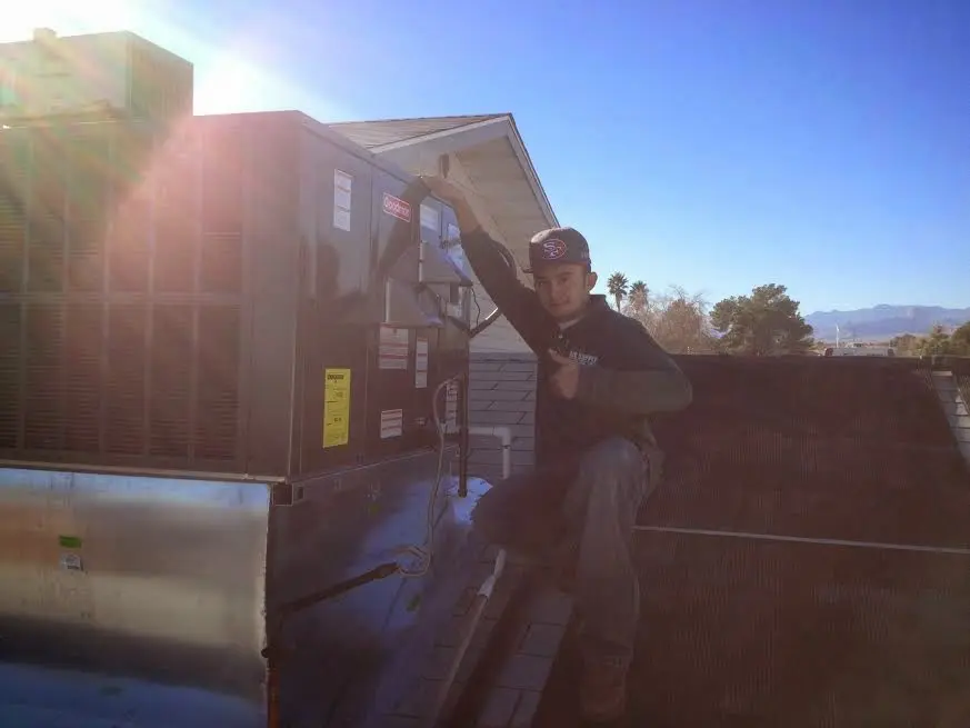 HVAC technician performing AC Tune-Up on a rooftop unit in Paradise Valley